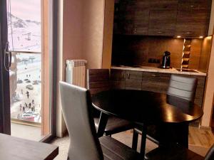 a table and chairs in a kitchen with a view at 2-room Apartment NFT New Gudauri 505 in Gudauri