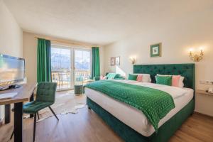 una camera d'albergo con letto, scrivania e TV di Vitalhotel Kaiserhof a Seefeld in Tirol