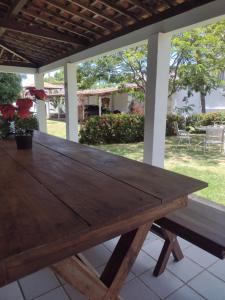 a wooden table on a patio with a bench at Casa Porto de Pedras_Patacho_Milagres in Pôrto de Pedras
