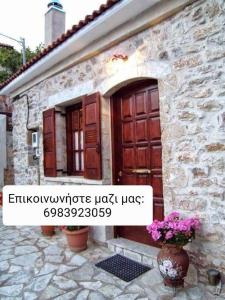 a stone house with a door and a vase of flowers at Mountain Ηouse in Arcadia in Vitina