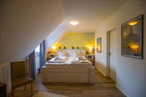 um quarto com uma cama grande num sótão em Stadthotel-Garni Smutje em Norden