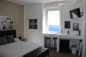 Seascape Rooms في كاتانيا: غرفة نوم بسرير ومدفأة ونافذة
