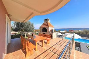 a patio with a table and a fireplace on a house at Modern House Giulia in Dobropoljana