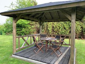 a wooden deck with a table and chairs on it at Dünentau in Norden