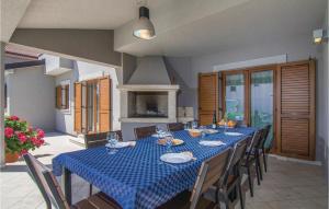 a dining room with a blue table and chairs at 4 Bedroom Awesome Home In Trosti in Heki