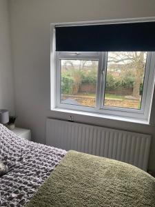 1 dormitorio con cama y ventana en BYRON SQUARE COTTAGE, en Hucknall