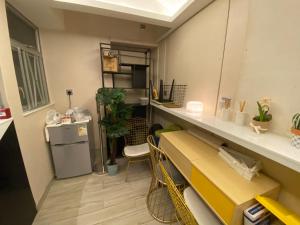 a room with a kitchen with a table and a shelf at Pop E INN-B&B in Hong Kong