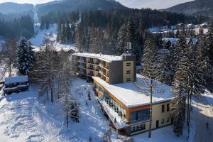 a building in the snow with snow covered trees at Hotel Hrabovo in Ružomberok
