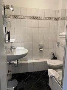 海德堡的住宿－四季飯店，白色的浴室设有水槽和卫生间。