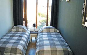 2 camas en una habitación con ventana en Bungalowpark Wijdland - Botter, en Bunschoten