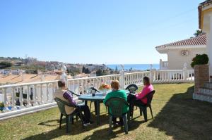 a group of people sitting around a table on a balcony at Villa Jacaranda Pool & Sea at Cala del Moral in Cala del Moral +31 photos