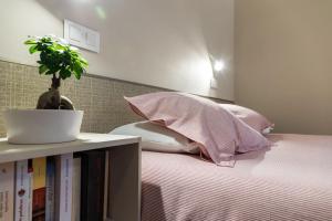 a bed with pink pillows and a plant on a shelf at Apartamentos en Baztan HIRU KABI, BAGA 