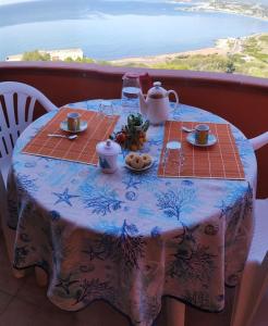 a table with a tea set on top of a balcony at Zafiro House in Magomadas