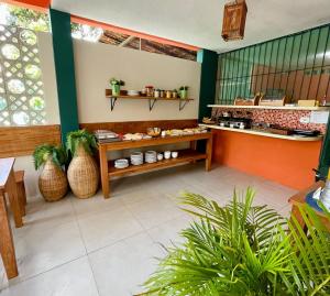 a restaurant with a counter with plants in a room at Chalés Praias do Sul in Porto De Galinhas