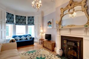 a living room with a blue couch and a fireplace at Blue Seas in North Berwick