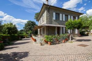 una casa con macetas delante de ella en Casa Pupa- Azienda Fontelunga, en Cortona