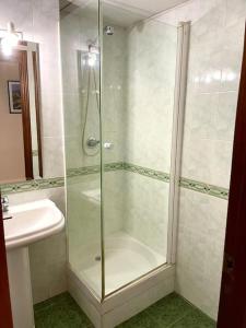 um chuveiro com uma porta de vidro ao lado de um lavatório em Apartamento Zoco Córdoba em Córdoba