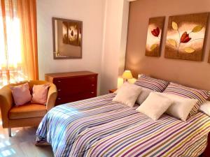 una camera con un grande letto e una sedia di Apartamento Zoco Córdoba a Cordoba