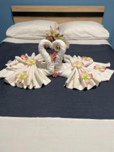 Dos cisnes hechos de toallas en una cama en Lefteris Apartment en Kardámaina