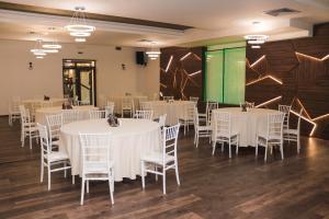 - une salle de banquet avec des tables et des chaises blanches dans l'établissement Paradise Park, à Polski Trŭmbesh