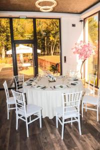une grande table blanche avec des chaises et des fleurs blanches dans l'établissement Paradise Park, à Polski Trŭmbesh