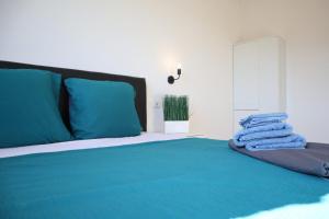 een slaapkamer met een bed met blauwe lakens en blauwe kussens bij Budoni Villetta Arno P1 in Budoni