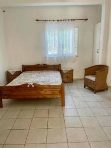 sypialnia z łóżkiem, oknem i krzesłem w obiekcie House with view the Ionian sea w Prewezie