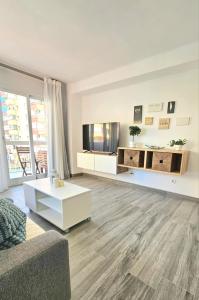 a living room with a couch and a tv at Mavi Torre del Mar in Torre del Mar