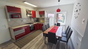 a kitchen with red cabinets and a table with chairs at Apartma4us in Maribor