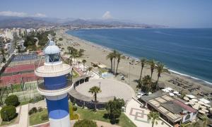 a lighthouse on a beach next to a beach at Mavi Torre del Mar in Torre del Mar