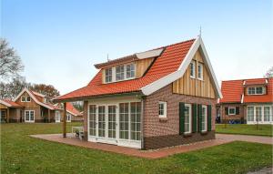 una casa con techo naranja en un patio en Gorgeous Home In Hoge Hexel With Kitchen en Hoge-Hexel