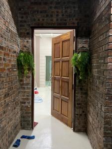 an open door in a brick wall with potted plants at RUMAH CHANGGONG Studio in Kota Bharu
