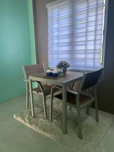 een houten tafel met 2 stoelen en een tafel met bloemen bij RUMAH CHANGGONG Studio in Kota Bharu