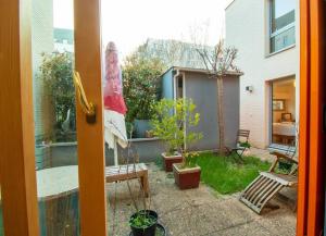 una puerta que da a un patio trasero con un jardín con plantas en Splendid Modern House near Roland Garros, en Boulogne-Billancourt
