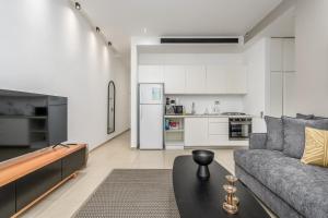 un soggiorno con divano e tavolo di New branded APT by Sea u TLV a Tel Aviv