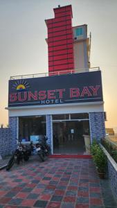 un hôtel au coucher du soleil avec une moto garée devant dans l'établissement Sunset Bay Hotel, à Cox's Bazar