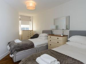 um quarto com 2 camas e um espelho em By The Sea em North Berwick