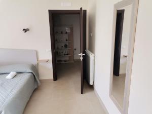 1 dormitorio con cama y espejo junto a una puerta en Montesarchiorooms en Montesarchio