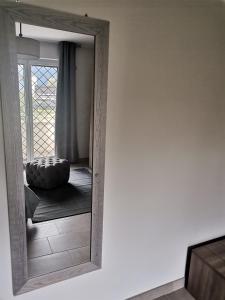 un espejo en una habitación con un sofá delante en Montesarchiorooms en Montesarchio