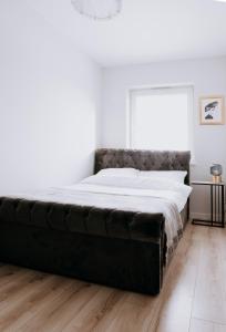 a large bed in a white bedroom with a large mattress at Apartament Symfonia Mozarta in Warka