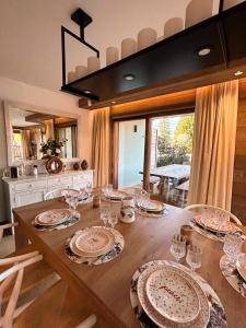 - une table à manger avec des assiettes et des verres dans l'établissement Les Chamois D’Arbois, Mont D’Arbois, Megève, à Megève