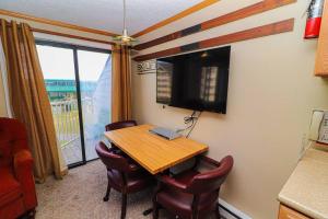 a room with a table and chairs and a television at ML328A 1BR Quiet corner unit! Close to Ballhooter in Snowshoe