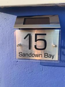 um relógio no lado de uma parede azul em “BLISS ON THE BAY ” chalet in Sandown Bay Holiday Park em Sandown
