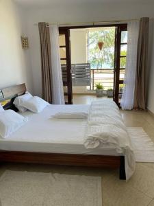 a large bed in a room with a window at Cozy 2-bedroom beachfront villa-Lamera in Mombasa +66 photos