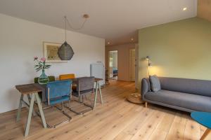 een woonkamer met een bank en een tafel bij Landgoed Wilgenheerd in Wehe-den Hoorn