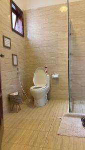a bathroom with a toilet in a wooden wall at Cozy 2-bedroom beachfront villa-Lamera in Mombasa