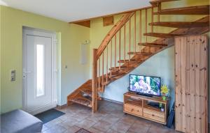 a living room with a tv and a wooden staircase at Nice Home In Wohlenberg With Kitchen in Wohlenberg