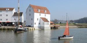 a small sail boat in the water next to a building at SkyFall in Woodbridge