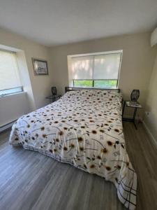 a bedroom with a bed with a comforter and two windows at Ocean Edge resort two bedroom and two bathroom condo. in Brewster