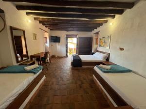 a hotel room with two beds and a table at EcoHotel Barichara in Barichara